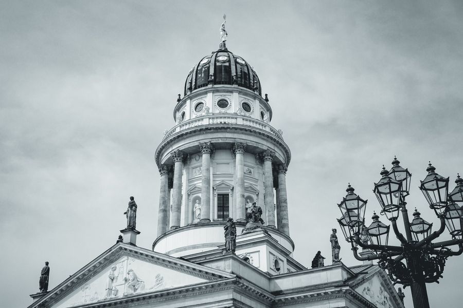 Una farola histórica de Berlín acompaña a la cúpula en un encuadre apaisado y sereno.