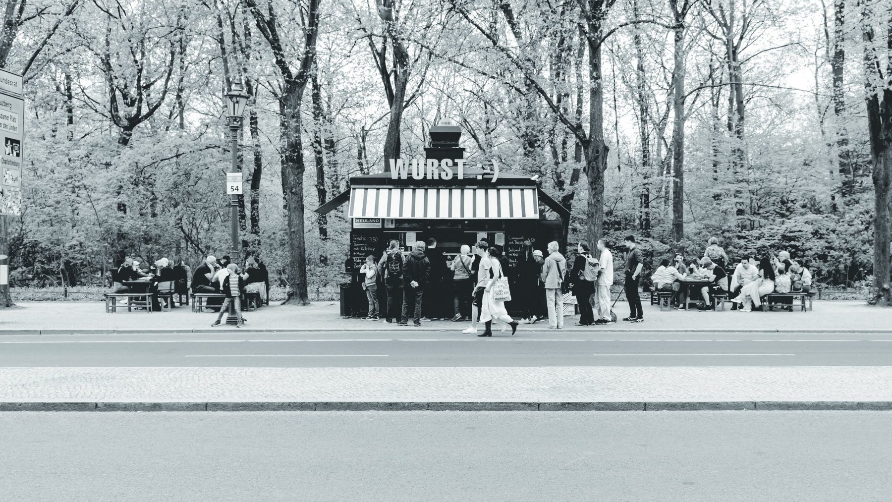 Un quiosco de salchichas bajo los árboles del Tiergarten, con su corrillo de clientes.