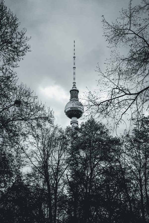 La Torre de Televisión de Alexanderplatz enmarcada por árboles todavía desnudos.