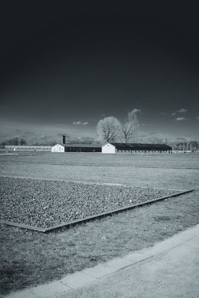 Gravel foundations in the foreground and the reconstructed barracks behind.