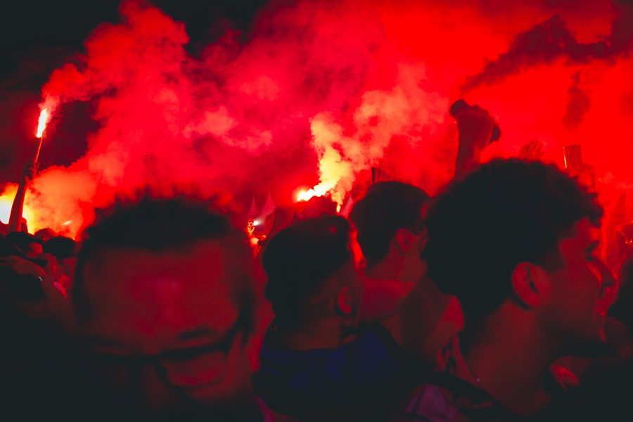 Entre cabezas a contraluz, un móvil graba la noche teñida de rojo.