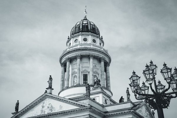 Una farola histórica de Berlín acompaña a la cúpula en un encuadre apaisado y sereno.