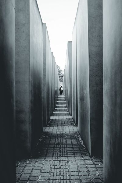 Un pasillo entre las estelas del Memorial. Al fondo, dos figuras diminutas dan la escala.
