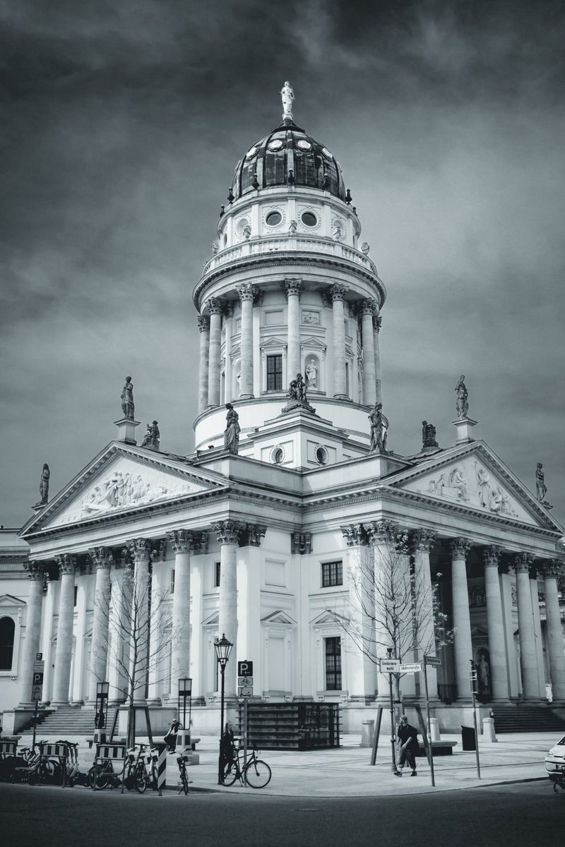 The temple seen from the corner, with bicycles, street lamps and passers-by at its feet.