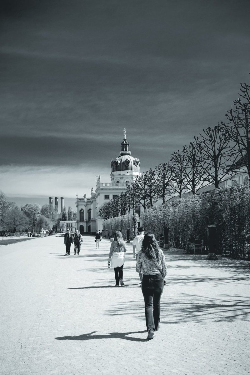 The garden avenue of Charlottenburg Palace, with its dome in the distance and a row of clipped trees.