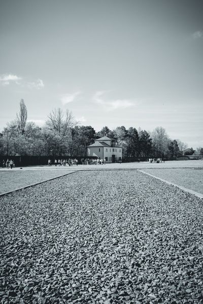Gravel marks the site of a vanished barrack. In the distance, Tower A and the visitors.