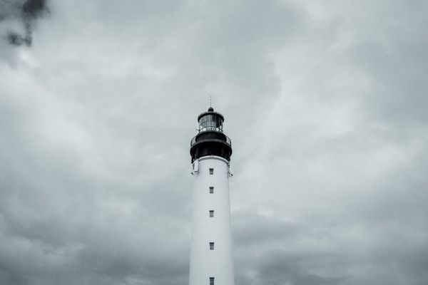 La torre blanca y su linterna de 1832 contra un cielo cerrado.