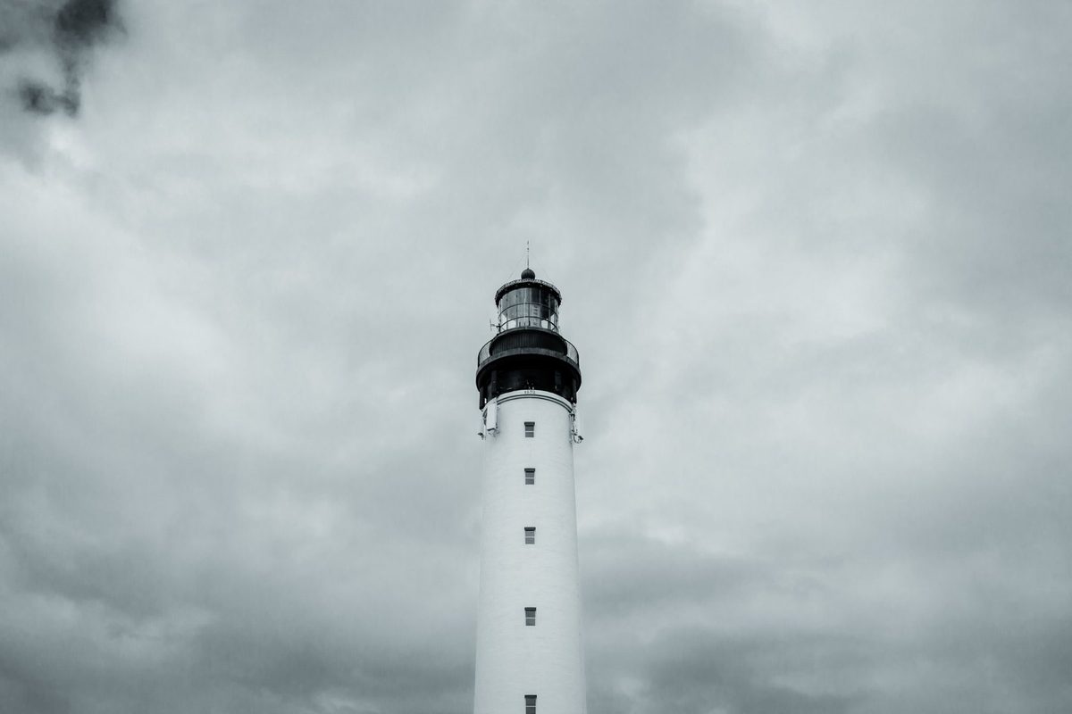The white tower and its 1832 lantern against an overcast sky.