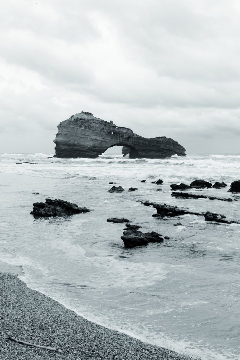 The shingle shore and loose rocks in front of the Roche Percée.