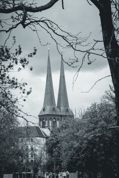 Las dos agujas de la Nikolaikirche asoman entre ramas y copas de primavera.