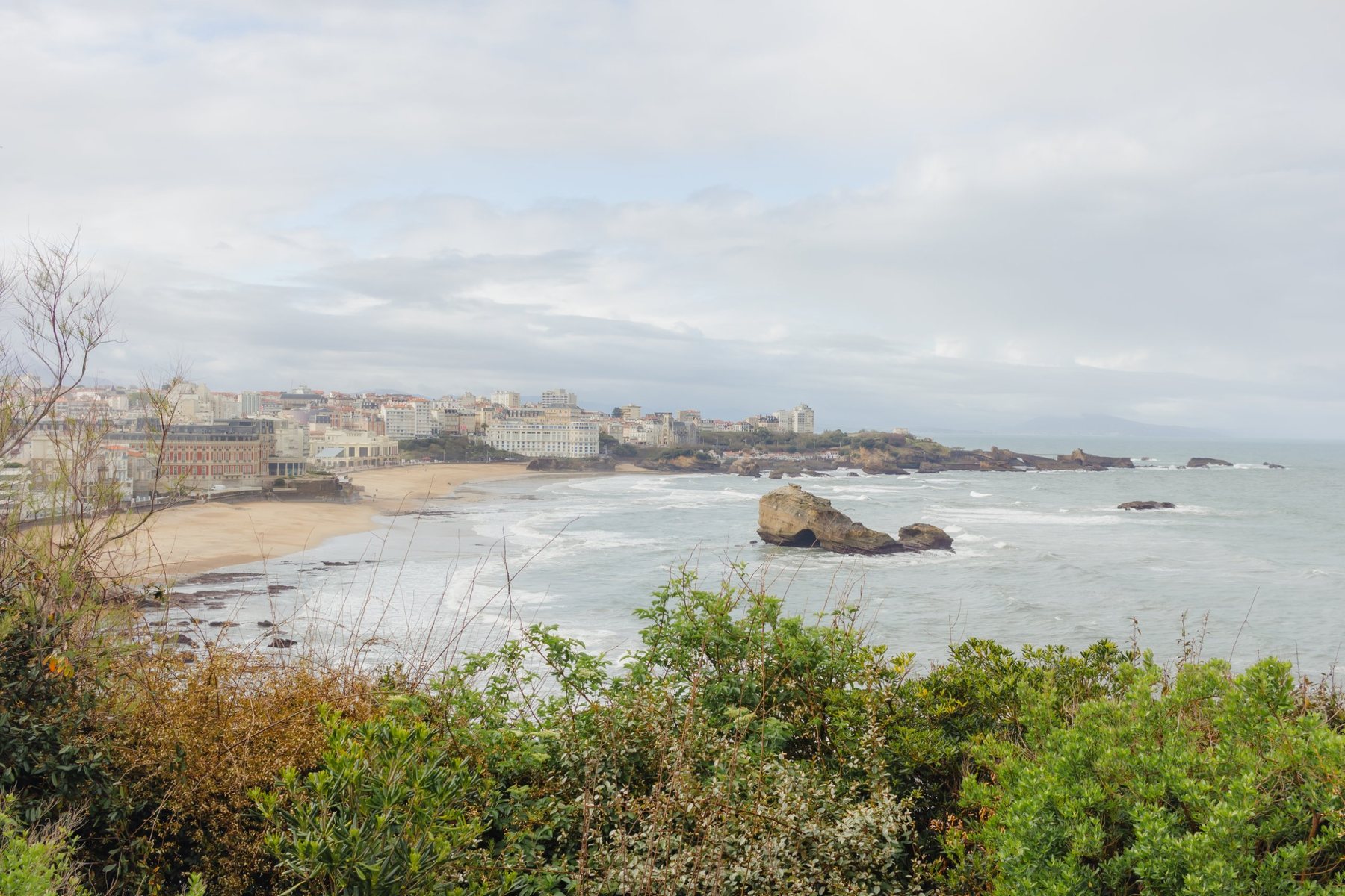 La bahía de Biarritz desde lo alto: la Grande Plage, el Hôtel du Palais y el casino, con el mar revuelto.