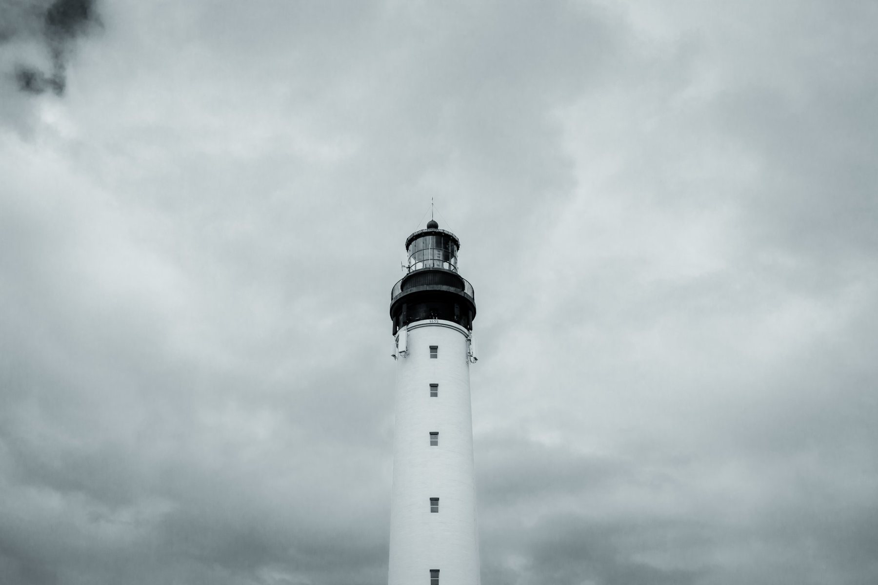 La torre blanca y su linterna de 1832 contra un cielo cerrado.